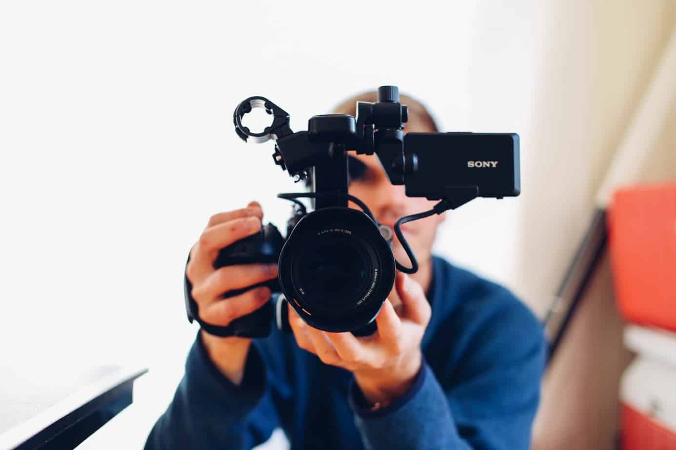 A photo of a man behind a video camera